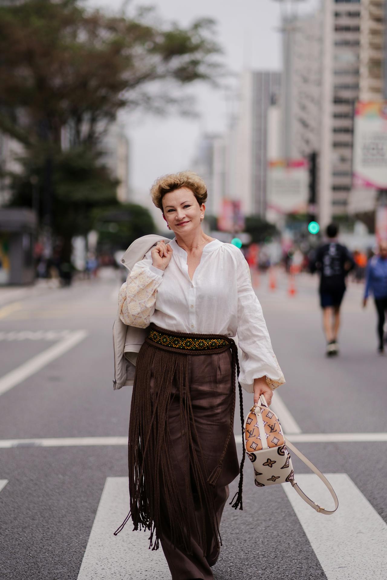 Stylish woman demonstrating bohemian pattern mixing in summer street outfit
