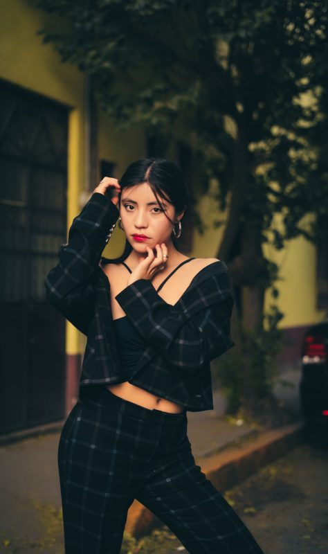 Confident young woman in plaid co-ord outfit posing on outdoor urban street