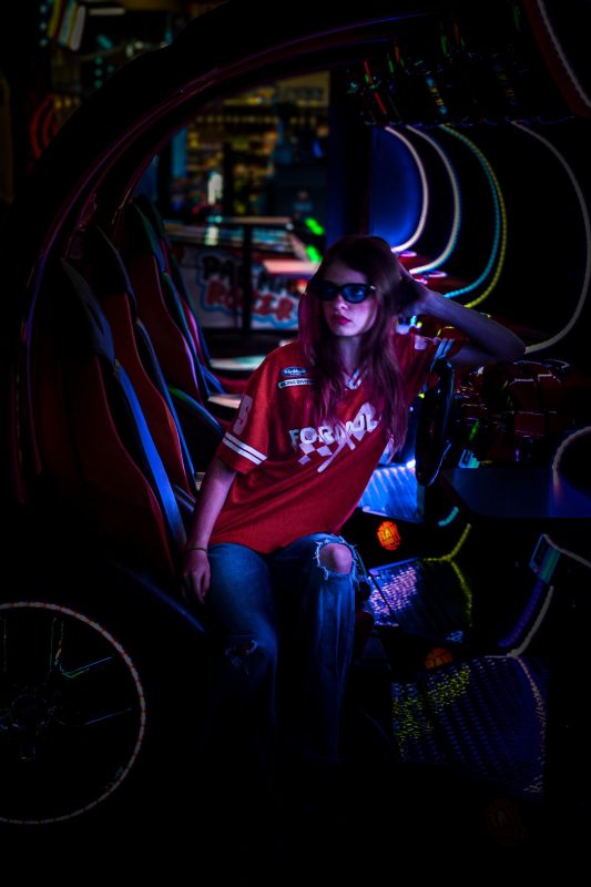 Stylish woman in red jersey, ripped jeans and sunglasses